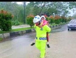 Kasat Lantas ini Gendong Anak SD untuk Menyeberang Jalan di Lokasi Banjir