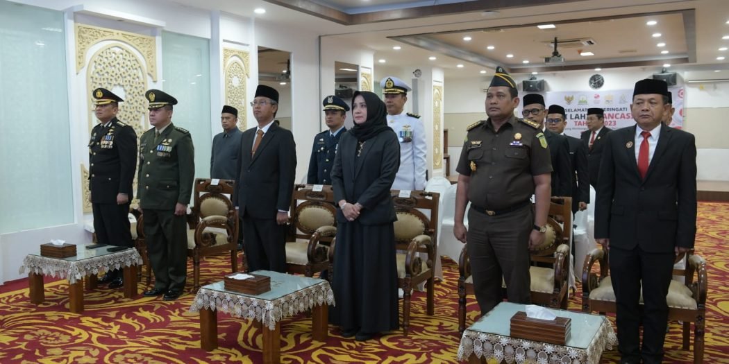 Asisten Administrasi Umum Sekda Aceh, Dr. H. Iskandar, AP, S.Sos, M.Si, bersama perwakilan Forkopimda Aceh, Ka. SKPA/Biro, Perwakilan Tni/Polri dan ASN Pemerintah Aceh, saat mengikuti Upacara Peringatan Hari Lahir Pancasila yang dipimpin langsung Oleh Presiden RI, Ir. H. Joko Widodo secara virtual dari Lapangan Silang Monas Jakarta, di Ruang Potda Setda Aceh, Banda Aceh, Kamis (1/6/2023).