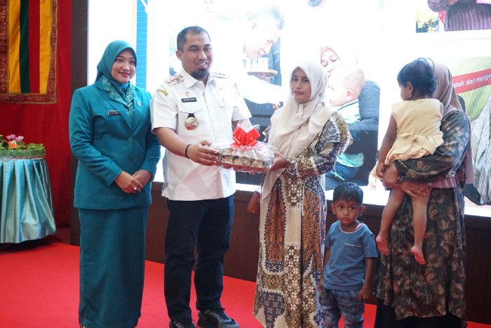 Pj Bupati Aceh Besar, Muhammad Iswanto SSTP MM bersama Pj Ketua TP-PKK Aceh Besar, Cut Rezky Handayani, SIP MM menyerahkan bantuan telur kepada anak stunting pada peringatan HKG PKK Ke-51 di Meuligo Bupati Aceh Besar, Rabu (11/10/2023).