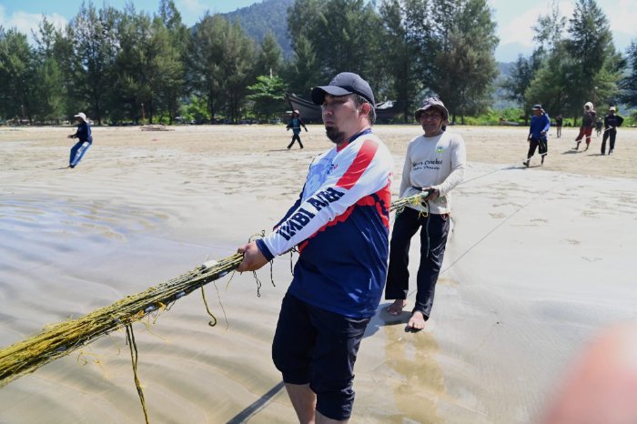 Pj Bupati Aceh Besar, Muhammad Iswanto S.STP MM menarik pukat bersama nelayan di pantai Pasi Jantang, Kecamatan Lhoong, Aceh Besar, Rabu (21/02/2024).