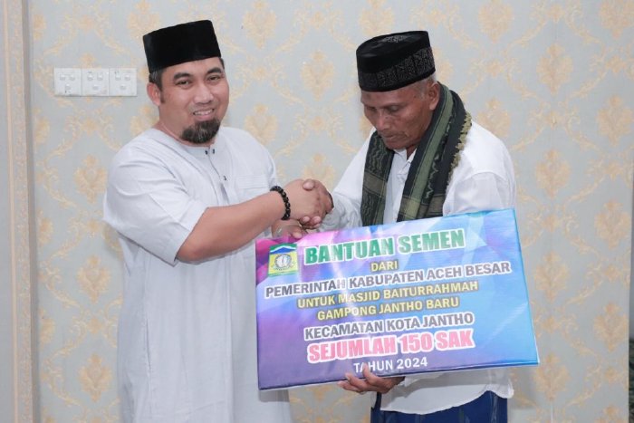 Pj Bupati Aceh Besar Muhammad Iswanto SSTP MM, menyerahkan bantuan material pembangunan untuk Masjid Baiturrahmah Jantho Baru secara simbolis kepada Imam Masjid Tgk Muhammad Juned.