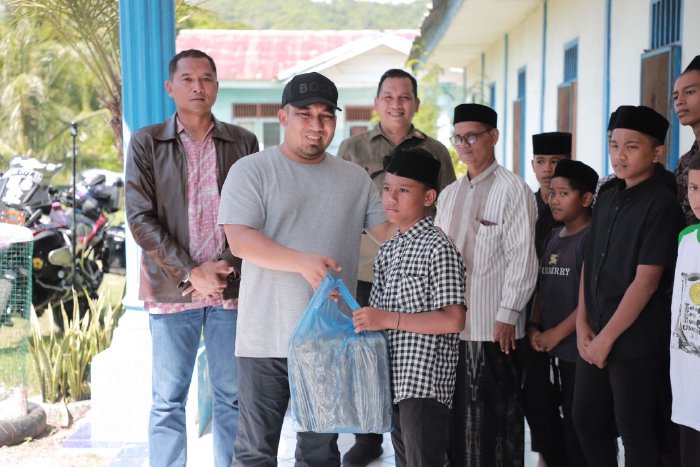 Pj Bupati Aceh Besar Muhammad Iswanto SSTP MM bersama Danlanud SIM Kolonel Pnb Hantarno Edi Sasmoyo menyerahkan sembako kepada anak yatim Rumah Singgah Bumi Moro, di Gampong Garot, Darul Imarah, Aceh Besar, Minggu (28/4/2024).