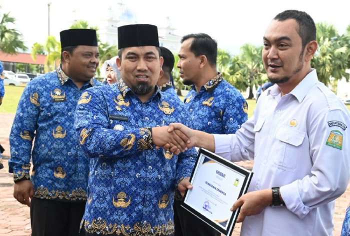 Pj Bupati Aceh Besar Muhammad Iswanto SSTP MM menyerahkan Piagam Penghargaan kepada sejumlah Kepala Puskesmas Pemkab Aceh Besar pada upacara Peringatan Hari Koperasi Indonesia ke 77 dan Hari Anak ke 40 di halaman Kantor Bupati Kota Jantho, Aceh Besar