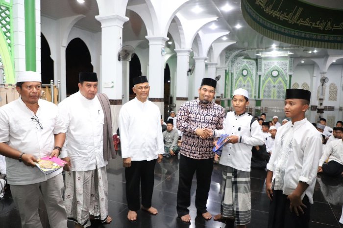 Pj Bupati Aceh Besar Muhammad Iswanto SSTP MM menyerahkan kitab kepada santri pada saat meluncurkan program "Beut Kitab" bagi santri Pesantren Al Fauzul Kabir di Mesjid Agung Al Munawwarah, Kota Jantho, Jumat (01/11/2024) malam. FOTO/PROKOPIM PEMKAB